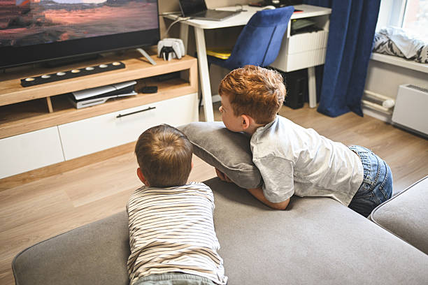 istock Two little brothers watching cartoons and playing games 2222149936
