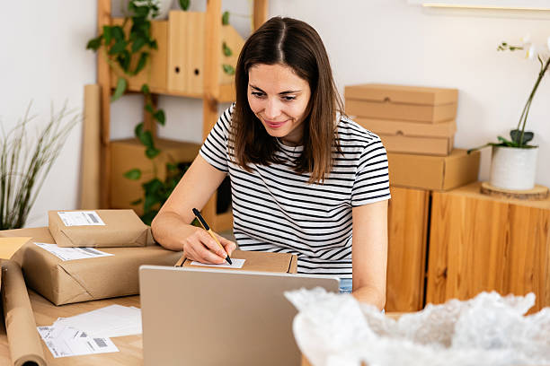 istock Young happy entrepreneur preparing a package for shipping in her home office 2222150270