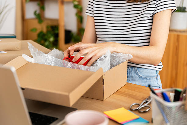 istock Young female entrepreneur carefully packing a red mug using bubble pack for shipping an online order 2222151316