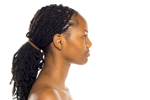 istock Black woman with braided ponytail in profile view, bare shoulders, studio shot on white background. 2222151447