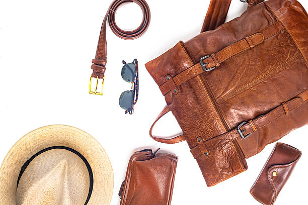 istock Leather backpack, hat, and accessories on white background. Stylish brown leather accessories close-up. View from above. 2222152953