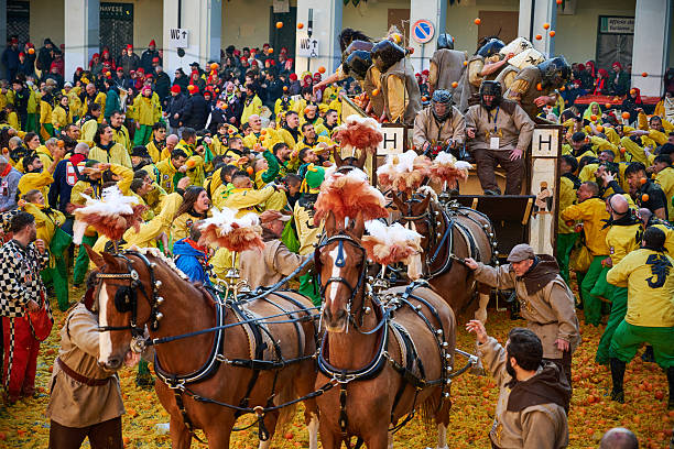 Ivrea, Italy - March 02, 2025: groups in traditional dressing take part in the Battle of the Oranges, where a teams of orange handlers on foot throw oranges (representing old weapons and stones) against aranceri of the team \