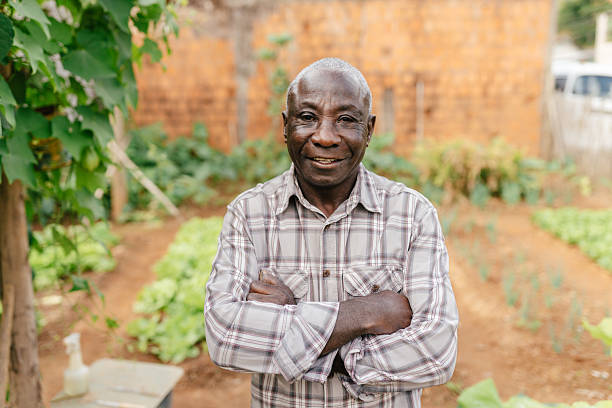 istock Elderly man smiling in his backyard vegetable garden 2222159626