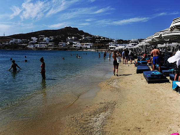 Mykonos, Greece: September 11, 2018 - Paradise Beach with bathers and hill
