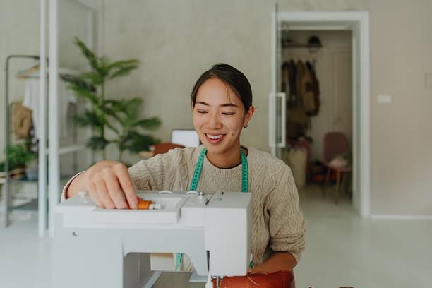 istock Young fashion designer using a sewing machine in her home studio 2222162461