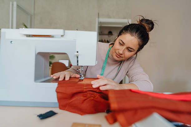 istock Young fashion designer using a sewing machine in her home studio 2222162533