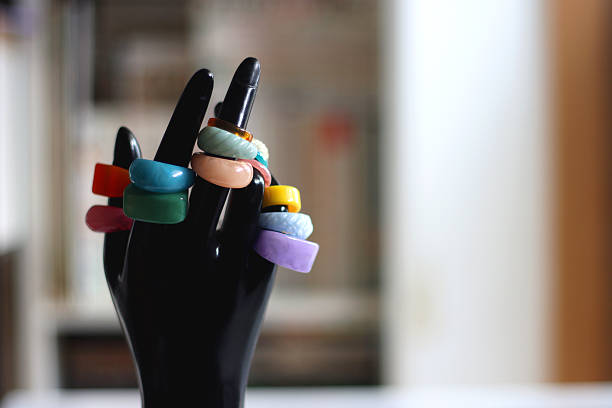Hand figurine with colorful various rings. Selective focus.