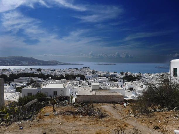 Mykonos, Greece: September 13, 2018 - Town in distance with sea and windmills