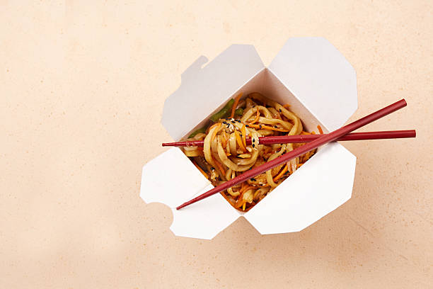 istock Noodles served in a white takeout box with chopsticks on a simple background 2222165939