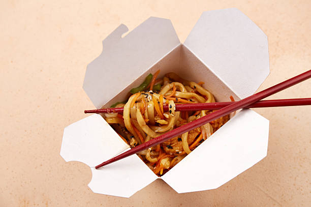 istock Noodles served in a white takeout box with chopsticks on a simple background 2222165955