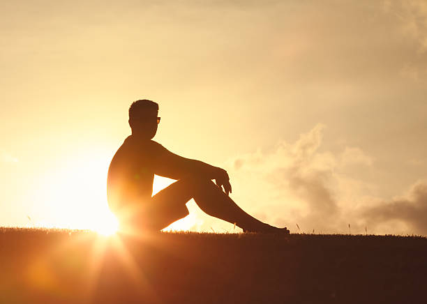 istock Thoughtful man sitting watching the sunset, self reflection, contemplation in nature alone with your thoughts. 2222172103