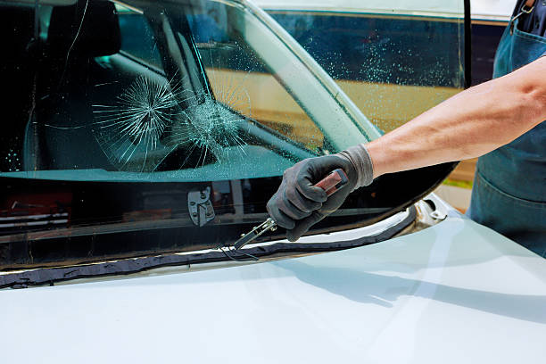 istock Car repair technician fixes cracked windshield at an auto shop garage under replacement damaged windshield 2222173793