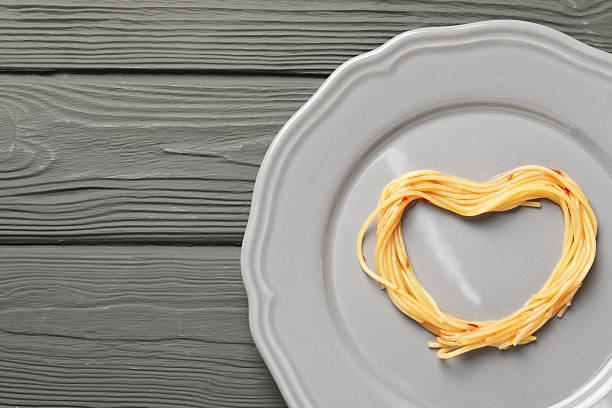 istock Heart made with spaghetti on grey wooden table, top view. Space for text 2222182858