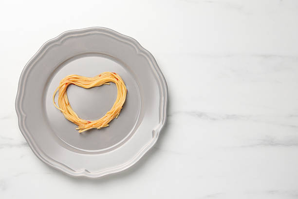 istock Heart made with spaghetti on white table, top view. Space for text 2222182860