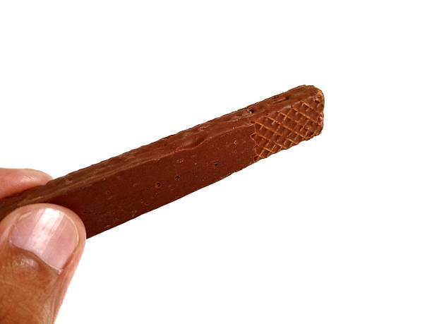 istock Hand pose holding chocolate wafer with isolated color 2222183013