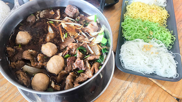 istock Stewed pork hot pot with white rice vermicelli and egg noodles served separately 2222183854