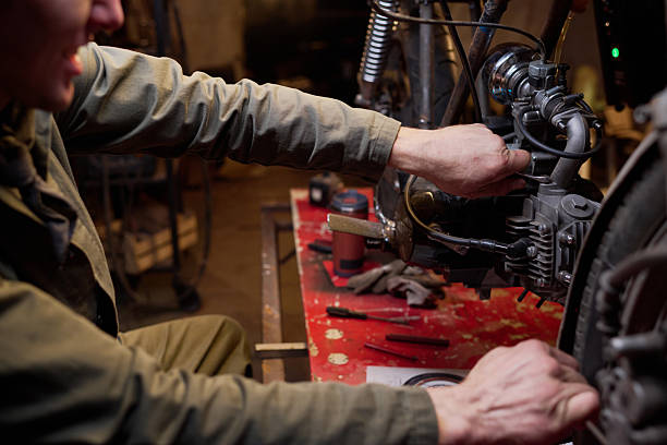 istock Middle Aged Caucasian Man Repairing Custom Motorcycle Engine in Workshop 2222186205