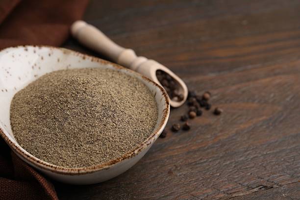 istock Ground pepper and peppercorns on wooden table, closeup. Space for text 2222189473