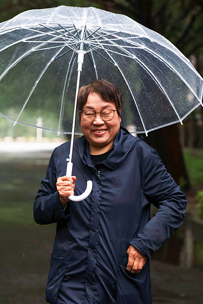 istock An elderly Asian woman is in the rain. 2222190181