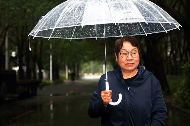 istock An elderly Asian woman is in the rain. 2222190201
