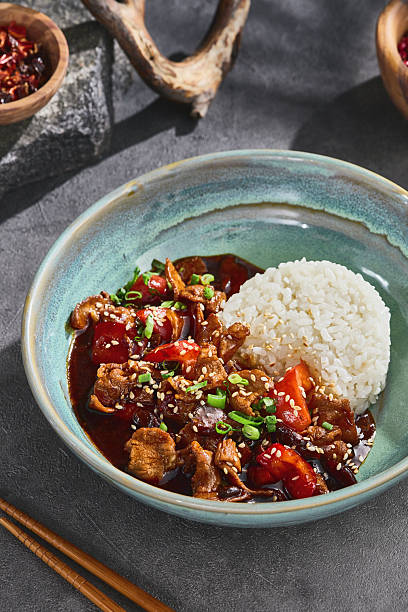 istock Pork stir fry, bright natural light, overhead composition, in rustic ceramic bowl with steamed rice 2222190527