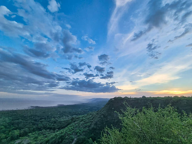 istock A breathtaking sunset paints the sky above serene mountains while a vibrant forest glows 2222190829