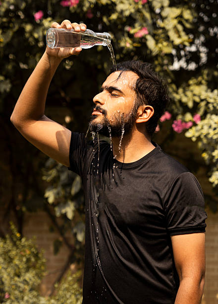 istock Refreshing Hydration: Man Cooling Down with Water on a Hot Day 2222190963