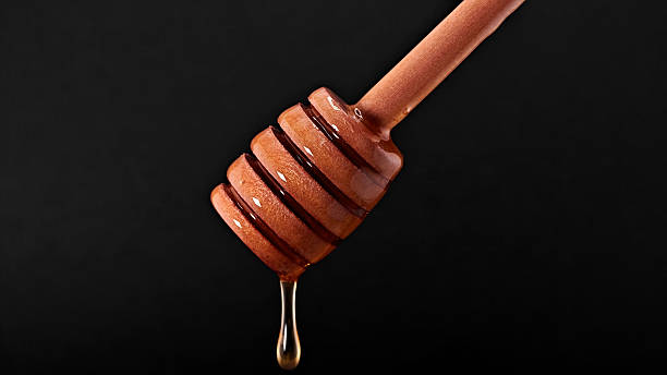 istock Wooden dipper with honey drop. 2222196438
