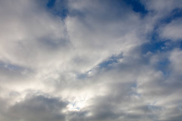 The sky is cloudy and the sun is shining through the clouds. The sky is blue and the clouds are white