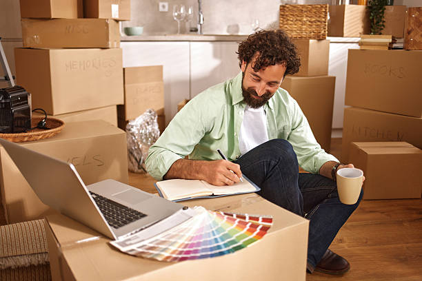 istock Man planning renovation in new home surrounded by boxes 2222200439