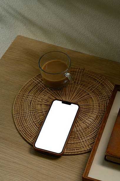 istock Smartphone with blank white screen placed on rattan coaster beside a cup of coffee 2222200455