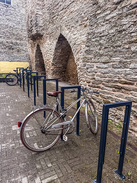 istock Old bicycle parked in modern rack by historic stone wall 2222201668
