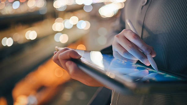 istock a person uses a tablet with financial data in a low-light urban setting, symbolizing night trading, business intelligence, and the rise of digital nomads in financial markets. 2222202091