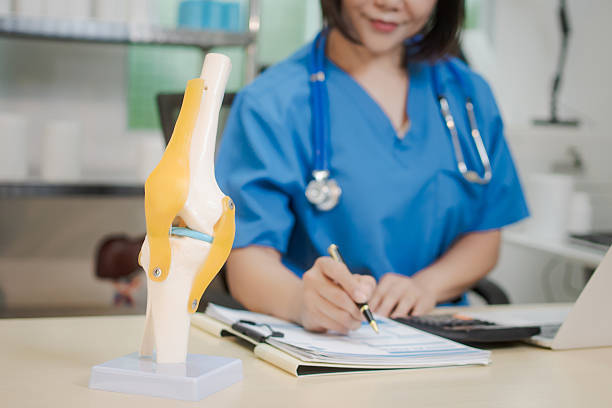 istock A middle-aged Asian female doctor at her desk,explaining various bone and joint diseases like arthritis,osteoporosis,and spinal disc degeneration,offering professional guidance in a clinical setting 2222203869