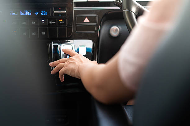 istock A driver is press on electrical AT gear shifter button of the modern car. 2222206442