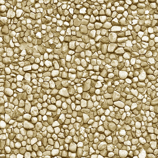 Natural beige pebble stone paving creating a seamless texture, ideal for backgrounds and design projects