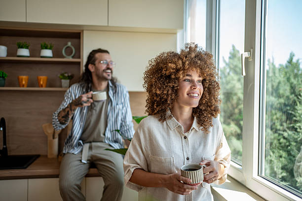 istock Happy couple enjoying morning coffee, looking out window in kitchen 2222208317
