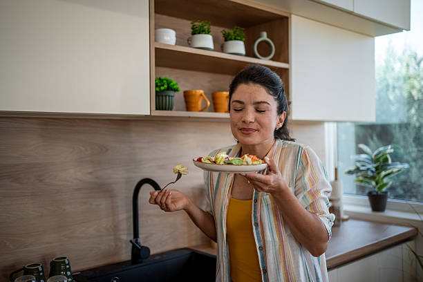 istock Woman enjoying fresh salad in modern kitchen 2222210842