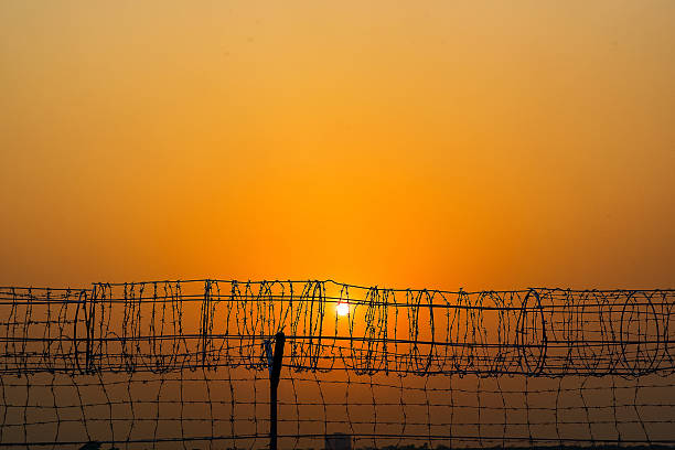 istock Sunset Behind Barbed Wire Fence  Symbolic Freedom and Restriction 2222211007