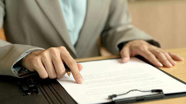 Businesswoman reads a contract document on a desk at office.