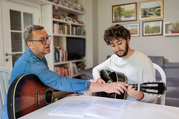istock Two Guitars, One Table: A Music Lesson Between Father and Son 2222213909