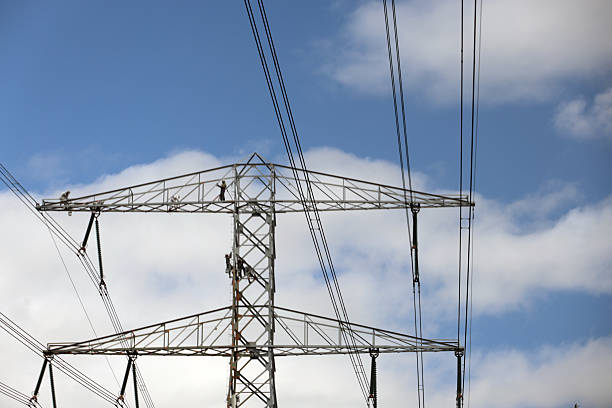 istock Painters in secure clothing work on a high-voltage mast 2222215743