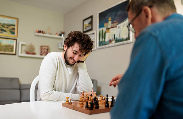 istock Father and son spending Father's Day thinking over a chess match 2222219912