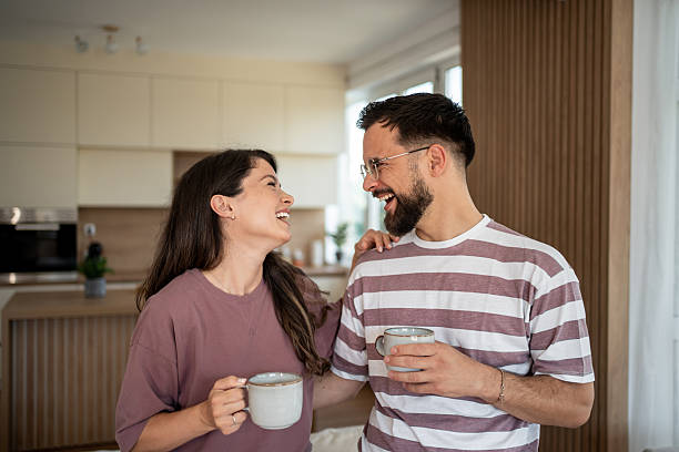 istock Happy couple laughing and drinking coffee in kitchen 2222220881