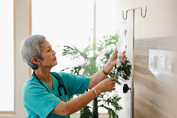 istock Asian senior nurse adjusting iv drip for patient. 2222222302