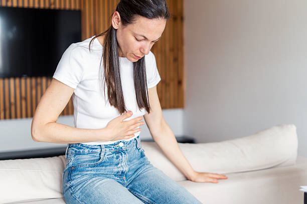 Woman experiences discomfort due to chronic illness while sitting at home