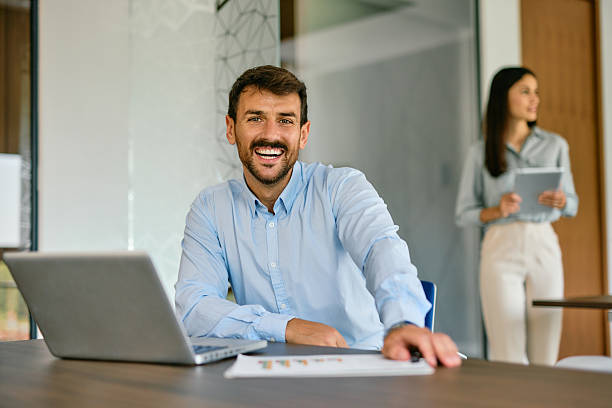 istock Young businessman smiling at camera in modern office 2222230716