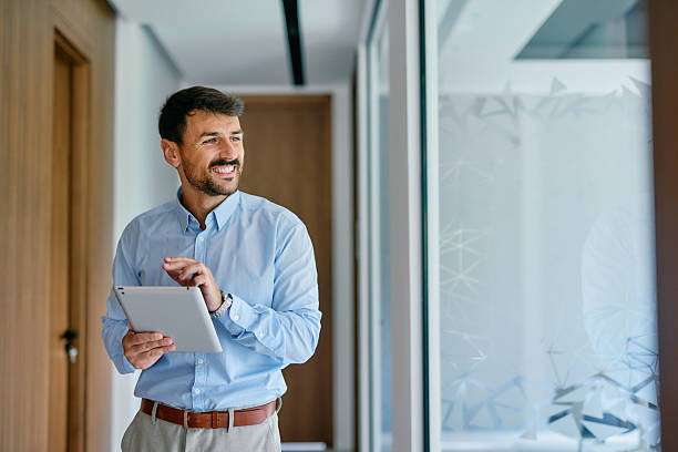 istock Smiling businessman using digital tablet in modern office 2222230737