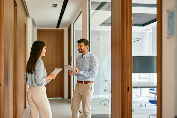 istock Business colleagues walking and talking in office corridor 2222230828