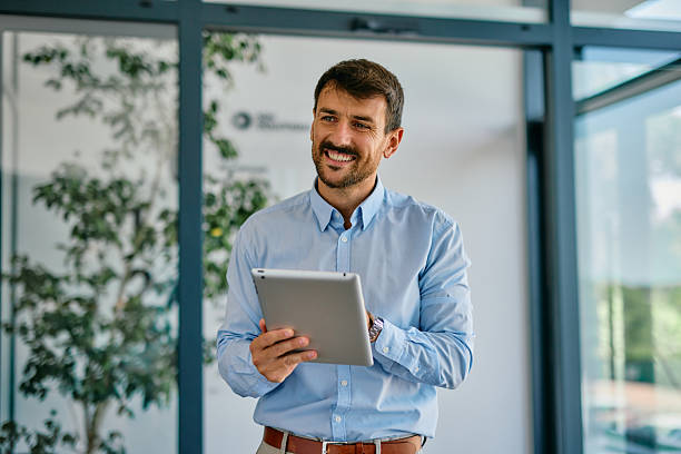 istock Smiling businessman using digital tablet in modern office 2222231079